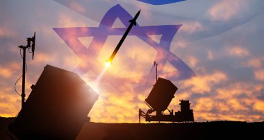 İsrail 'in Demir Kubbe hava savunma füzeleri fırlatılıyor. Füzeler gün batımında İsrail bayrağıyla gökyüzüne nişan alınmış. Füze savunması, yaylım ateşi sistemi..