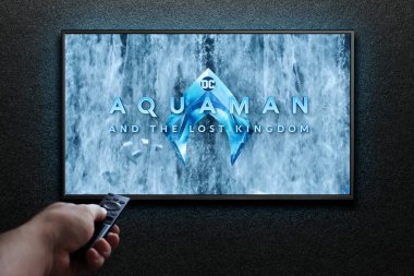 Aquaman ve Kayıp Krallık karavanı ya da TV ekranındaki film. Adam uzaktan kumandayla televizyonu açıyor. Astana, Kazakistan - 5 Aralık 2023.