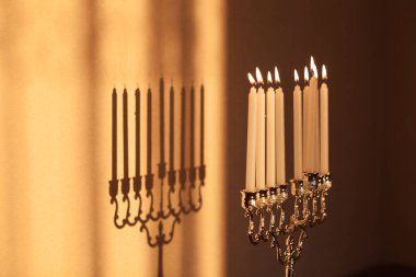 Hanuka menorası ya da gün batımında gün batımında Yahudi bayramı için Hanukkiah. Hanuka lambası, dokuz dallı şamdan. Duvarında gölgesi olan yanan mumlar..
