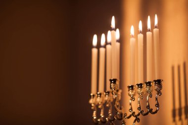 Hanuka menorası ya da gün batımında gün batımında Yahudi bayramı için Hanukkiah. Hanuka lambası, dokuz dallı şamdan. Duvarında gölgesi olan yanan mumlar..