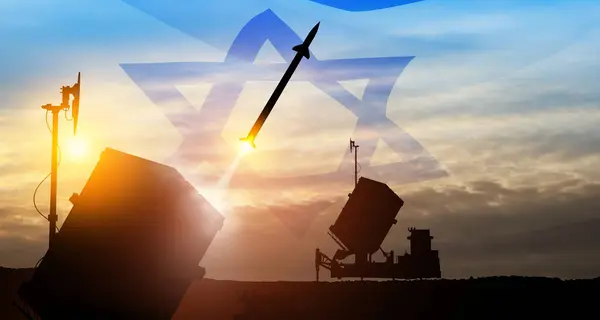 Closeup of Israel\'s Iron Dome air defense missile launches. The missiles are aimed at the sky at sunset with Israel flag. Missile defense, a system of salvo fire.