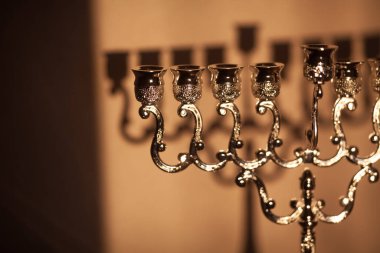 Hanuka menorası ya da gün batımında gün batımında Yahudi bayramı için Hanukkiah. Hanuka lambası, dokuz dallı şamdan. Duvarında gölgesi olan mumsuz..