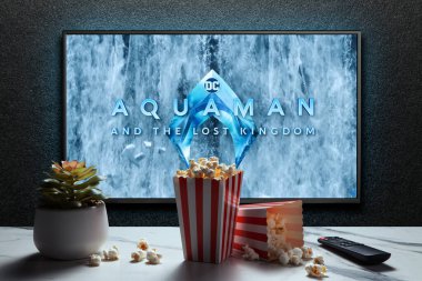 Aquaman ve Kayıp Krallık karavanı ya da TV ekranındaki film. Uzaktan kumandalı televizyon, patlamış mısır kutuları ve ev bitkisi. Astana, Kazakistan - 5 Aralık 2023.