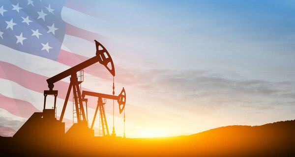 Изменение цен на нефть, вызванное войной. Концепция ограничения цен на нефть. Буровые установки на пустынном месторождении с флагом США. Добыча нефти из земли. Производство нефти.