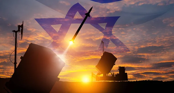 Closeup of Israels Iron Dome air defense missile launches. The missiles are aimed at the sky at sunset with Israel flag. Missile defense, a system of salvo fire.