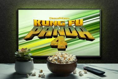 Kung Fu Panda 4 karavanı ya da TV ekranında film. Uzaktan kumandalı televizyon, patlamış mısır kasesi ve ev bitkisi. Astana, Kazakistan - 22 Mart 2024.