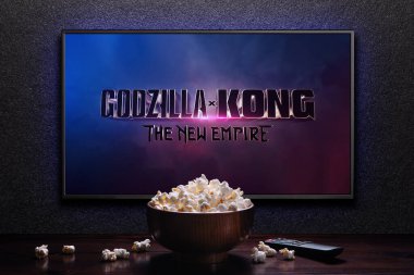 Godzilla x Kong Yeni İmparatorluk fragmanı ya da TV ekranındaki film. Uzaktan kumandalı televizyon ve patlamış mısır kasesi. Astana, Kazakistan - 22 Mart 2024.