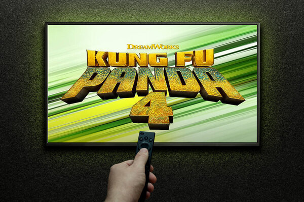 Kung Fu Panda 4 trailer or movie on TV screen. Man turns on TV with remote control. Astana, Kazakhstan - March 22, 2024.