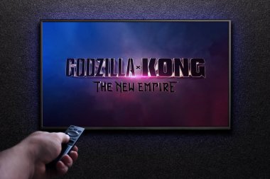 Godzilla x Kong Yeni İmparatorluk fragmanı ya da TV ekranındaki film. Adam uzaktan kumandayla televizyonu açıyor. Astana, Kazakistan - 22 Mart 2024.