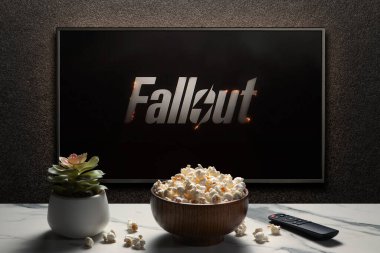 Amerikan televizyon dizisi Fallout fragmanı ya da TV ekranında bir film. Uzaktan kumandalı televizyon, patlamış mısır kasesi ve ev bitkisi. Astana, Kazakistan - 10 Nisan 2024.