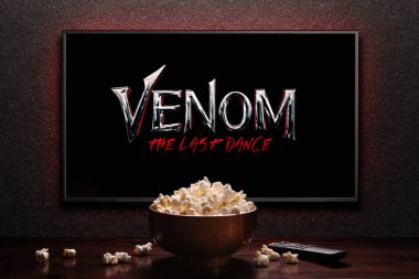 Venom The Last Dance fragmanı ya da TV ekranındaki film. Uzaktan kumandalı televizyon ve patlamış mısır kasesi. Astana, Kazakistan - 13 Haziran 2024.