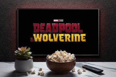 Wolverine ve Deadpool karavanı ya da TV ekranında bir film. Uzaktan kumandalı televizyon, patlamış mısır kasesi ve ev bitkisi. Astana, Kazakistan - 31 Temmuz 2024.