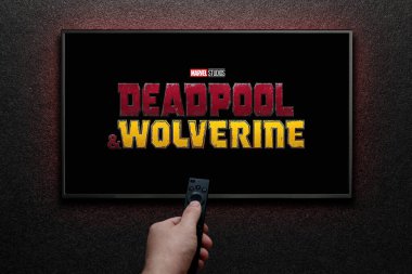 Wolverine ve Deadpool karavanı ya da TV ekranında bir film. Adam uzaktan kumandayla televizyonu açıyor. Astana, Kazakistan - 31 Temmuz 2024.