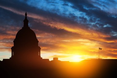 ABD Kongre Binası, gün batımında Washington DC 'de uçan kuşlarla gökyüzünün arka planında siluet inşa ediyor..
