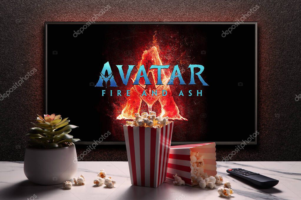 TV screen playing Avatar Fire And Ash trailer or movie. TV with remote control, popcorn boxes and home plant. Astana, Kazakhstan - February 5, 2025.