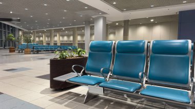 Boş sandalyeleri olan geniş bir havaalanı bekleme alanı. Akşam havaalanı binasında boş bekleme sandalyeleri..