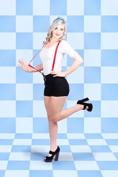 Gorgeous photo of a retro pin-up girl in full with a beautiful slim figure standing inside a vintage diner