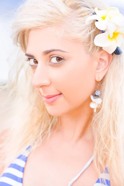 Fresh Clear And Blemish Free Beauty And Skincare Concept Amid A Pretty Beautiful Blonde Woman Smiling With A Yellow Frangipani Flower In Her Hair