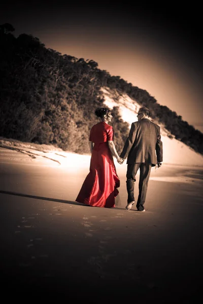 Happy Wedding Couple Take A Casual Stroll Along The Beach Of Love In A Celebration Of A New Life Together In Marital Bliss