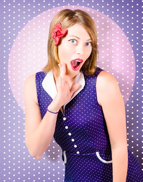 Old-fashioned retro photo of a charming pin-up woman with fun surprised expression on purple polka-dot background