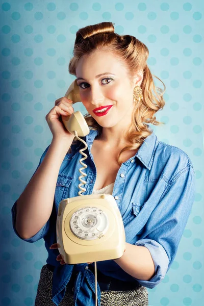 Beautiful Young Pin-Up Woman With Sixties Era Make-Up And Classical Hairstyle Posing With Retro Telephone While In Gossip Converse