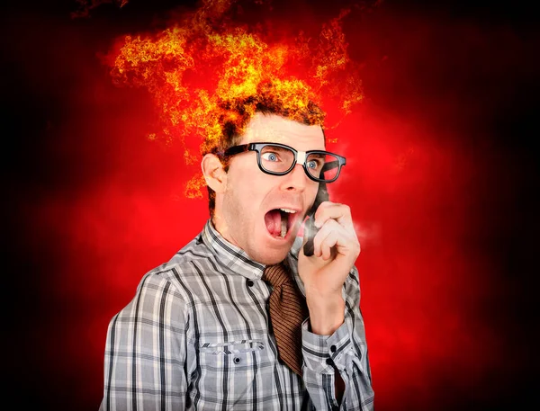 Funny portrait of a angry business man heaving heavy breaths of smoke with head engulfed in fire on mobile phone. Heated exchange