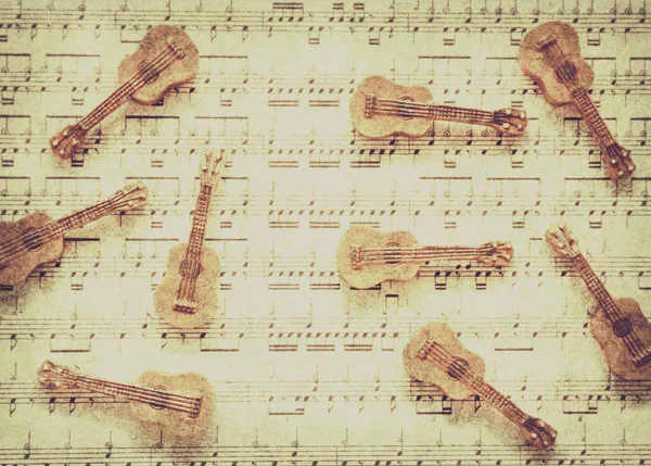 Classical rhythm art on scattered old string instruments placed ornately on lined music chart. Vintage guitar music