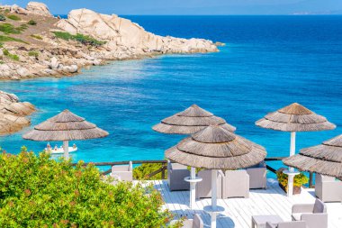 Luxury umbrellas on the italian island Sardinia in mediterranean sea.  clipart