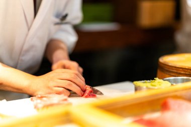 Tokyo, Japonya 'da bir omakase restoranında kırmızı ton balığı dilimleyen suşi şefi.