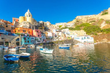 Procida limanı, renkli binalar, demirlemiş tekneler.