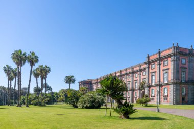 Napoli Capodimonte Kraliyet Sarayı güneşli bir günde görkemli bir şekilde yemyeşil bahçelerin ortasında duruyor.. 