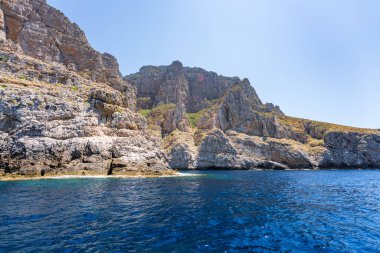 Kayalık kayalıklar güneşli bir günde Marettimo, Sicilya, İtalya 'da turkuaz denizle buluşur.