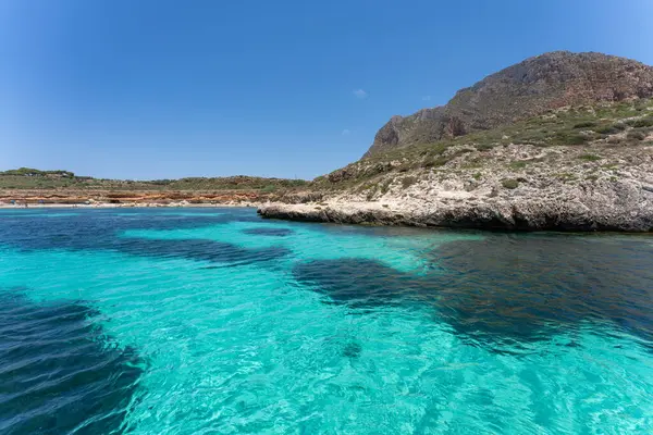Turkuaz sular, İtalya 'nın Favignana kentinde kayalık kıyı şeridiyle buluşuyor..