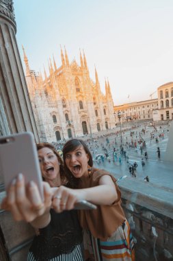 İki arkadaş Duomo di Milano 'nun önünde selfie çekiyor..