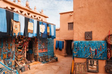 Fas 'taki dükkânda turistler için renkli tekstil ve mücevherler geleneksel bir ortamda sergileniyor.