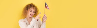 Yüzünde bir gülümseme olan genç mutlu bir kız ellerinde bir Amerikan bayrağı tutuyor. Vatanseverliğin ve özgürlüğün sembolü..