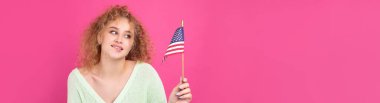 Yüzünde bir gülümseme olan genç mutlu bir kız ellerinde bir Amerikan bayrağı tutuyor. Vatanseverliğin ve özgürlüğün sembolü..