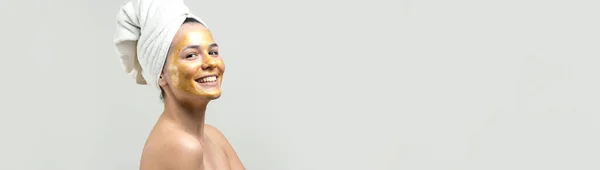 顔に金栄養マスクを頭の上に白いタオルの女性の美しさの肖像画 スキンケアクレンジングエコ有機化粧品スパリラックスコンセプト — ストック写真