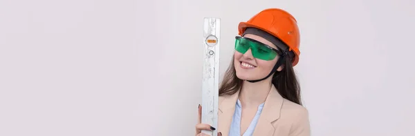 Ingenieurin Orangefarbenem Bauhelm Mit Einer Bauebene Den Händen Auf Weißem — Stockfoto