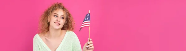 彼女の顔に笑顔の若い幸せな女の子は彼女の手にアメリカのフラグを保持しています 愛国心と自由の象徴 — ストック写真