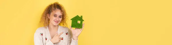 快乐的购房者 一个小女孩手里拿着一座绿色房子的模型 绿色能源 生态的概念 — 图库照片