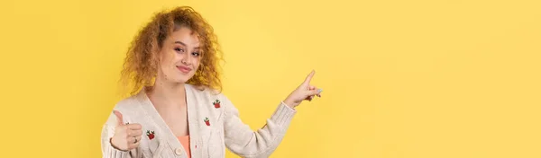 Młoda Dziewczyna Kręconymi Włosami Wskazuje Gestem Tle Studia — Zdjęcie stockowe