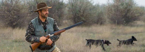 猎手在搜寻野鸟或猎物时带着枪进行伪装 — 图库照片