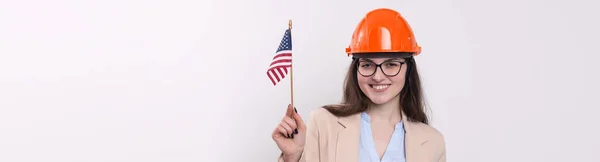Una Chica Casco Construcción Una Bandera Americana Mantiene Feliz Sobre — Foto de Stock