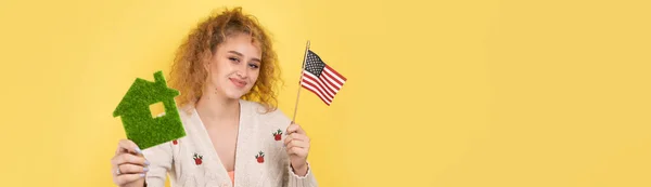 Молодая Девушка Держит Руках Модель Зеленого Дома Американский Флаг Концепция — стоковое фото