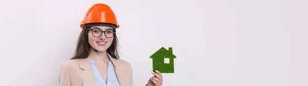 Uma Rapariga Num Capacete Construção Tem Uma Casa Verde Conceito — Fotografia de Stock