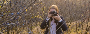 Elinde kamera olan komik pozlar veren bir kız çerçeveyi hazırlar. Paparazi 'nin elinde kamerayla dağlarda bir salgın var..