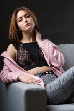 Kız pembe bir ceket ve siyah bir bluz giyiyor..