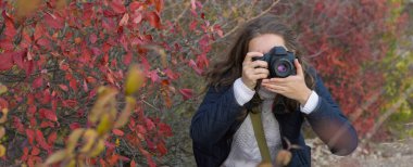 Elinde kamera olan komik pozlar veren bir kız çerçeveyi hazırlar. Paparazi 'nin elinde kamerayla dağlarda bir salgın var..