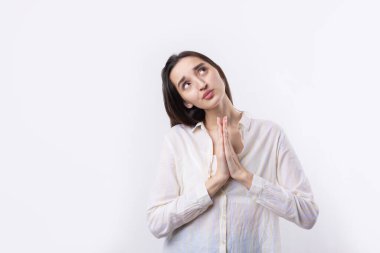 Avuç içi beyaz arka planda, dur hareketi gösteren ciddi bir genç kadının portresi.